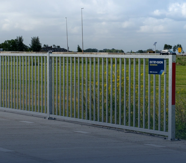 Witte vrijdragende schuifpoort bij een sportterrein