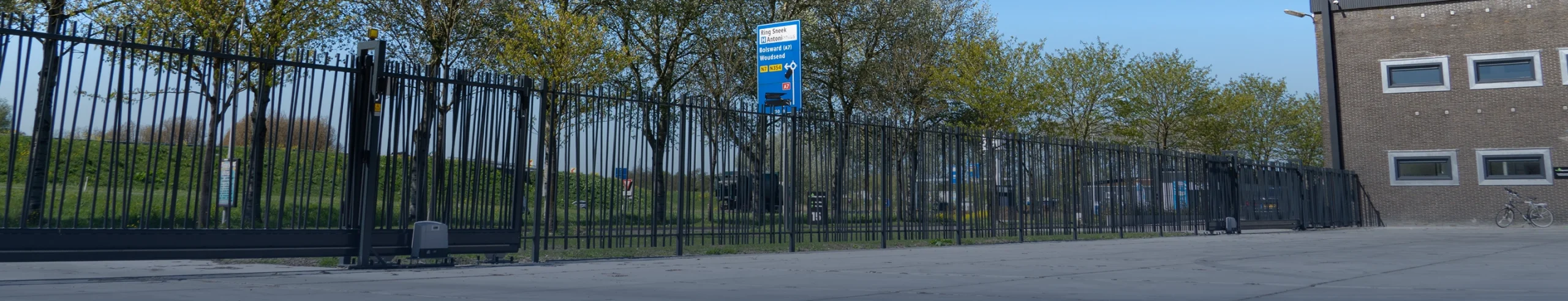 Elektrische schuifpoort met aandrijving en aansluitend terreinhekwerk
