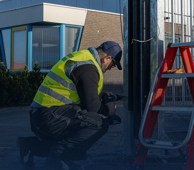 Monteur installeert een elektrische poortaandrijving