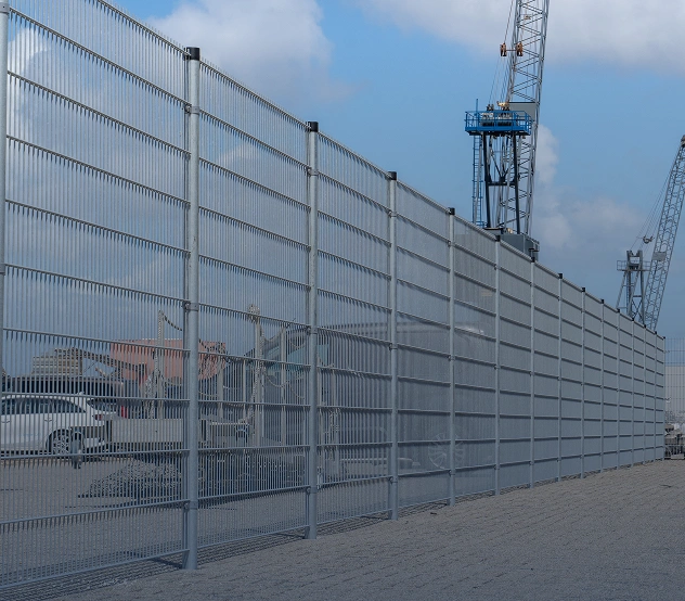 Hoog geluidswerend hekwerk langs een bedrijventerrein
