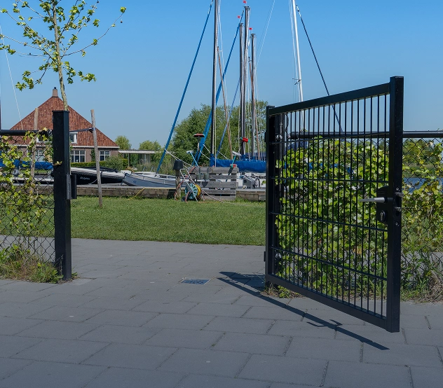Openstaande zwarte draaipoort bij een jachthaven